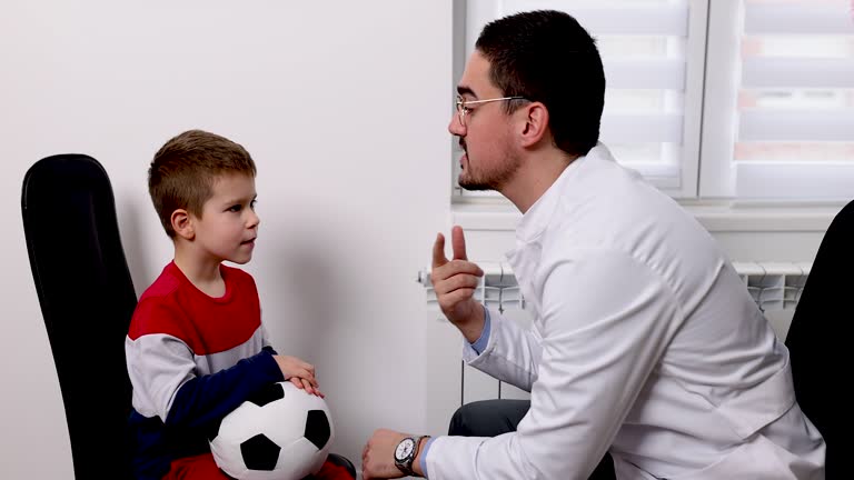 أخصائي تخاطب متميز يتفاعل بابتسامة مع طفل أثناء جلسة تنمية مهارات لغوية.